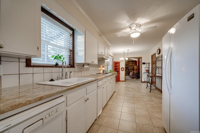 kitchen with pendant lighting, white appliances, sink, tasteful backsplash, and white cabinetry