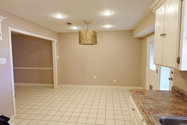 kitchen with decorative light fixtures, white cabinetry, and light tile patterned floors