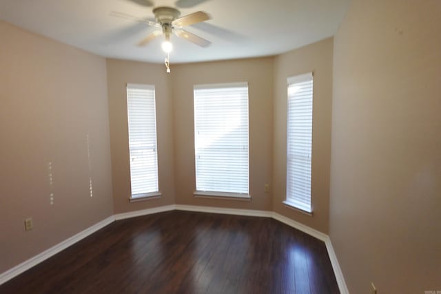 empty room with ceiling fan and dark hardwood / wood-style flooring