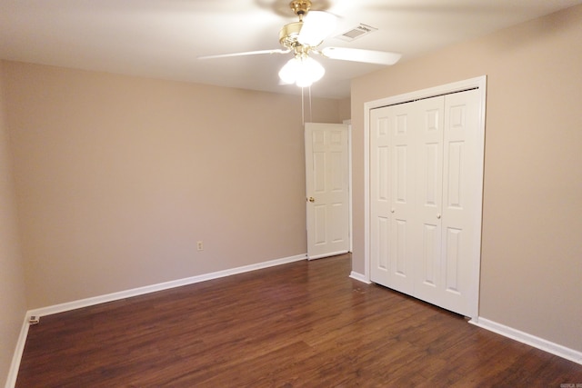 unfurnished bedroom featuring ceiling fan, a closet, and dark wood-type flooring