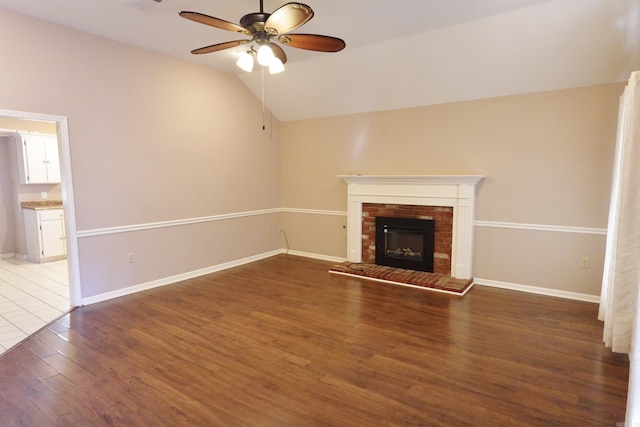 unfurnished living room with a fireplace, hardwood / wood-style flooring, ceiling fan, and lofted ceiling