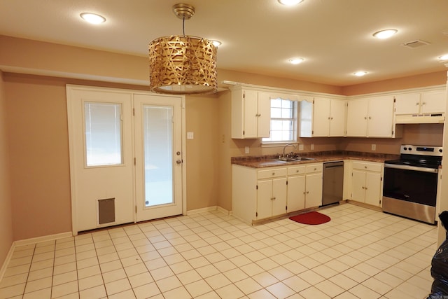 kitchen featuring sink, hanging light fixtures, light tile patterned floors, white cabinetry, and stainless steel appliances