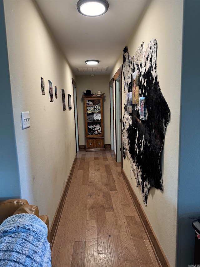 corridor with hardwood / wood-style flooring