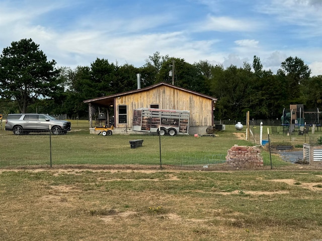 view of front of home with an outdoor structure and a front yard