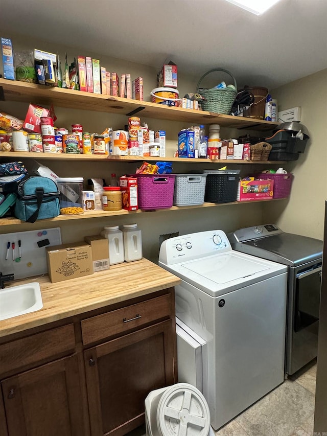 laundry room with cabinets, sink, and washer and dryer