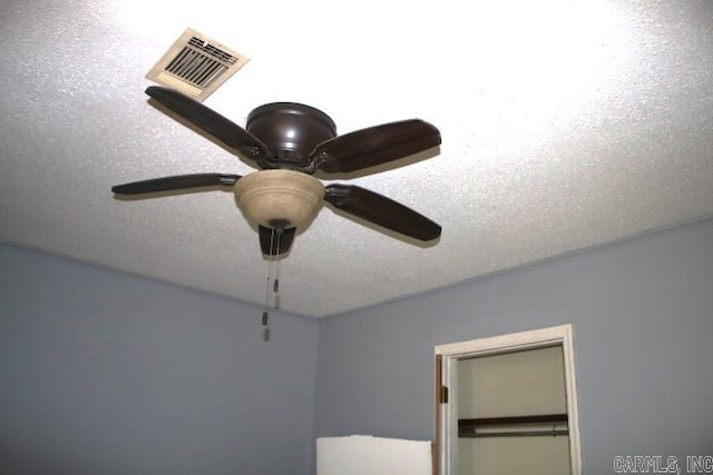 interior details with a textured ceiling and ceiling fan