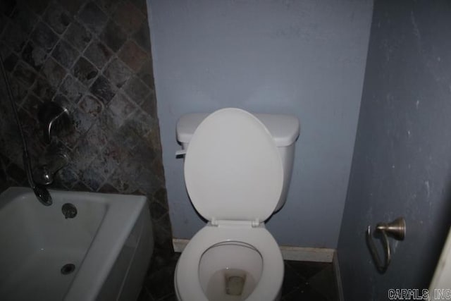 bathroom featuring a washtub and toilet