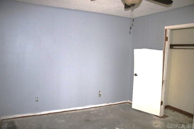 unfurnished bedroom featuring concrete flooring, a textured ceiling, a closet, and ceiling fan