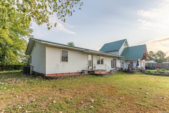 back of property featuring a lawn and central AC unit