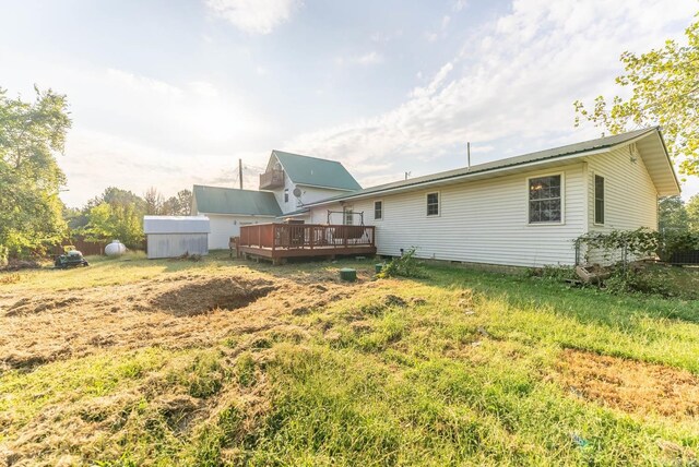 rear view of house with a wooden deck and a shed