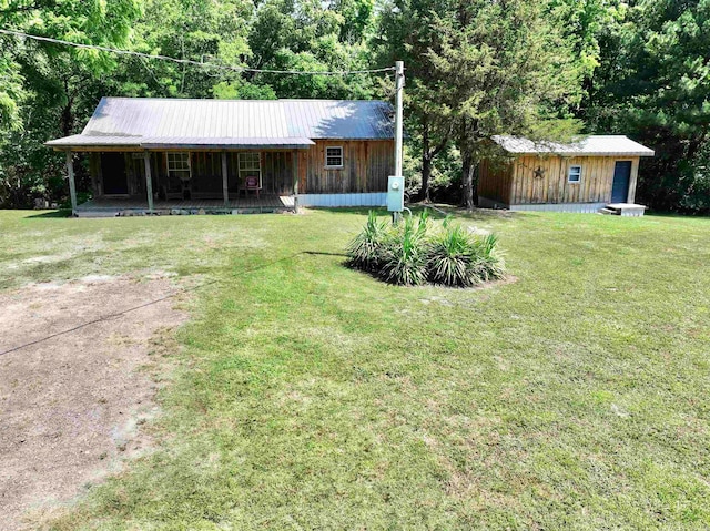 ranch-style house with a porch, a front lawn, and an outdoor structure