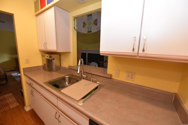 kitchen featuring white cabinetry, sink, and hardwood / wood-style floors