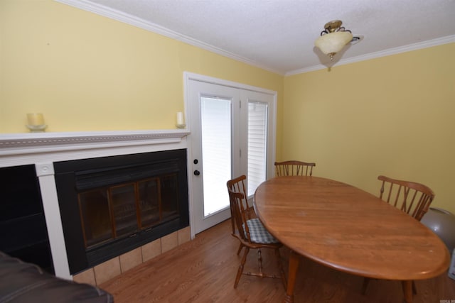 dining space with a wealth of natural light, crown molding, and light wood-type flooring