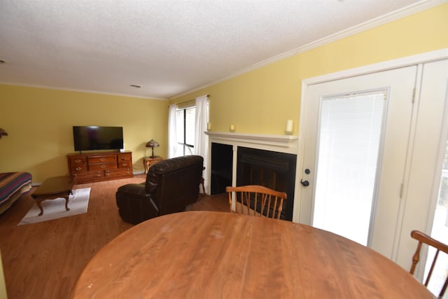 dining space featuring a textured ceiling, hardwood / wood-style flooring, and crown molding