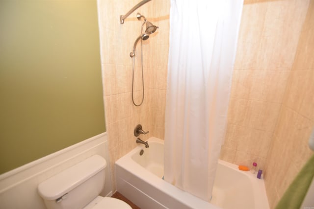 bathroom featuring toilet and shower / tub combo with curtain