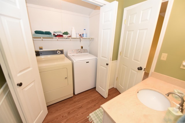 washroom featuring separate washer and dryer, light hardwood / wood-style flooring, and sink