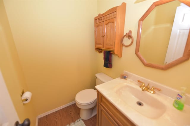 bathroom with vanity, wood-type flooring, and toilet