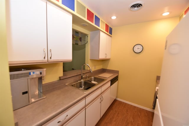 kitchen featuring white cabinetry, sink, dishwasher, and hardwood / wood-style flooring