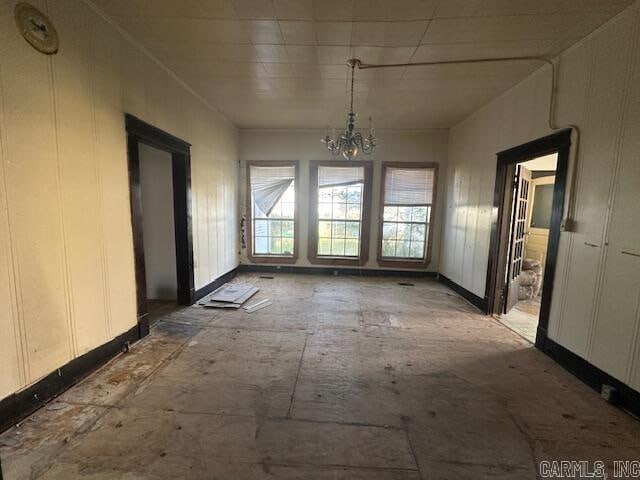 unfurnished dining area featuring a chandelier