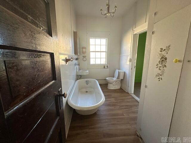 bathroom featuring shower / bath combination, an inviting chandelier, hardwood / wood-style flooring, and toilet