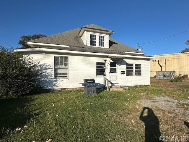 rear view of property featuring a yard