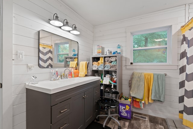 bathroom featuring a shower with shower curtain, vanity, and wooden walls