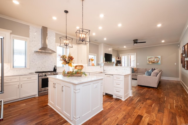 kitchen featuring white cabinetry, wall chimney exhaust hood, high end stainless steel range oven, and a kitchen island