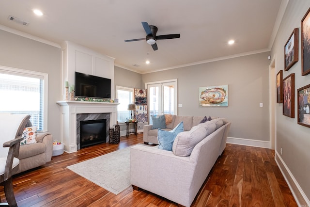 living room with a premium fireplace, dark hardwood / wood-style flooring, and crown molding