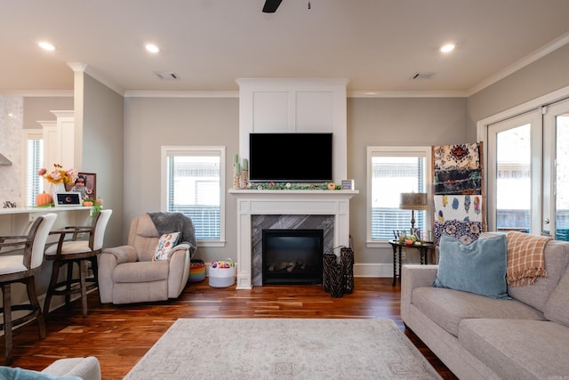 living room with a fireplace, dark hardwood / wood-style floors, ceiling fan, and ornamental molding