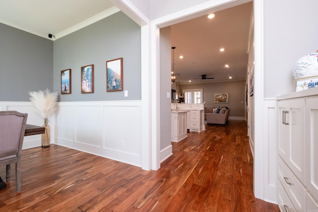 corridor with dark hardwood / wood-style flooring and crown molding