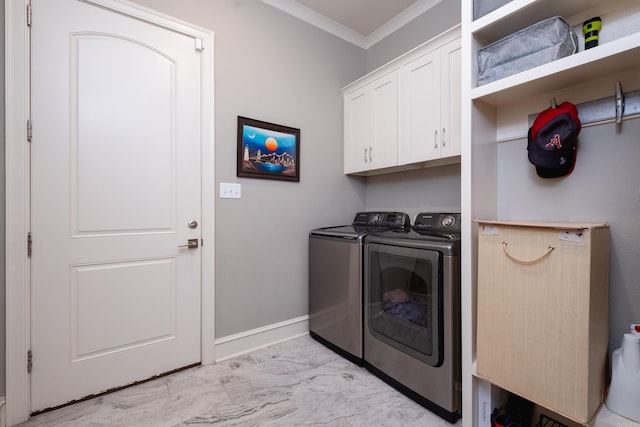 washroom with washer and dryer, crown molding, and cabinets