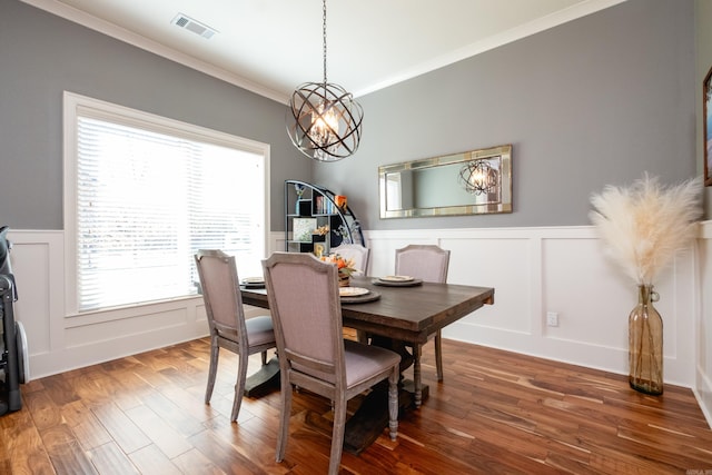 dining area with a notable chandelier, dark hardwood / wood-style flooring, and crown molding