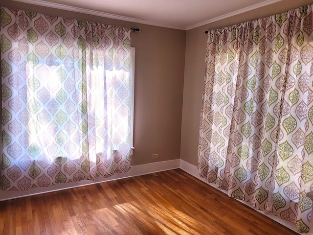 empty room with crown molding and hardwood / wood-style flooring