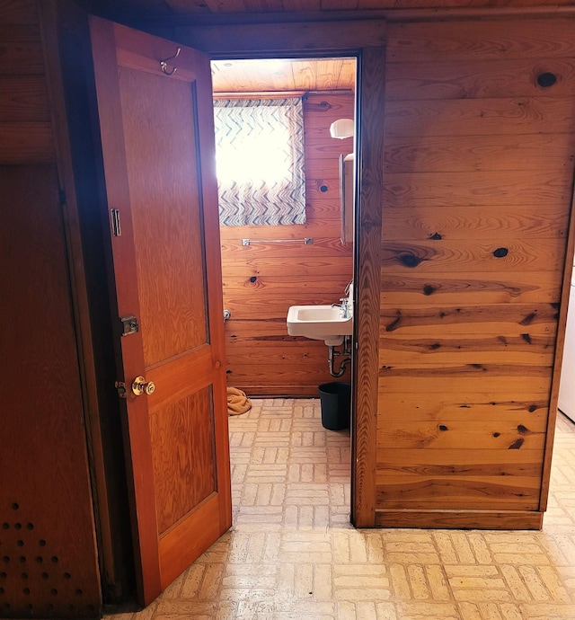 corridor featuring wood walls and sink