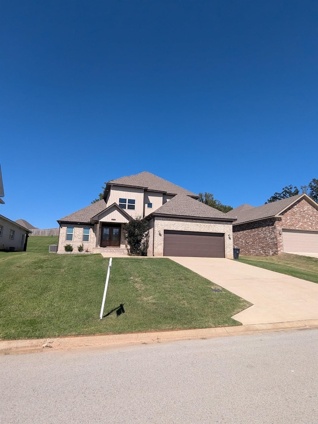 prairie-style home featuring a garage and a front lawn