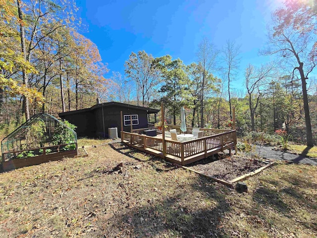 view of yard with an outbuilding, central AC, and a deck