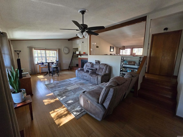 living room featuring a textured ceiling, ceiling fan, lofted ceiling, and hardwood / wood-style flooring