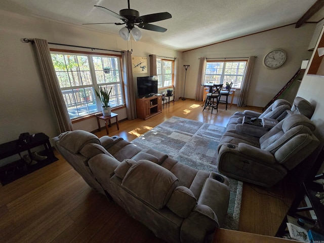 living room with a textured ceiling, ceiling fan, hardwood / wood-style floors, and vaulted ceiling