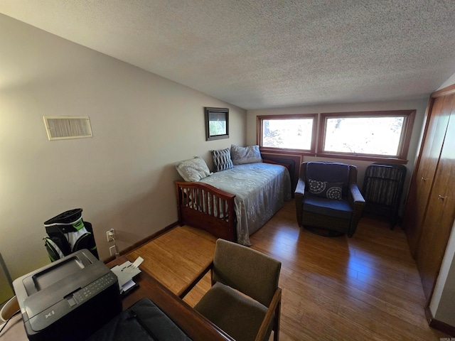 bedroom featuring hardwood / wood-style floors and a textured ceiling