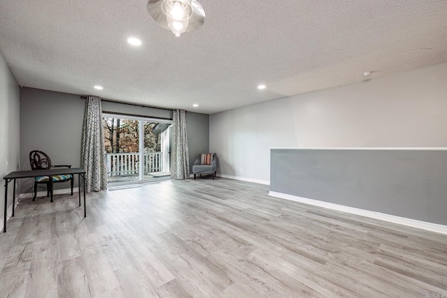 interior space with a textured ceiling and light hardwood / wood-style floors