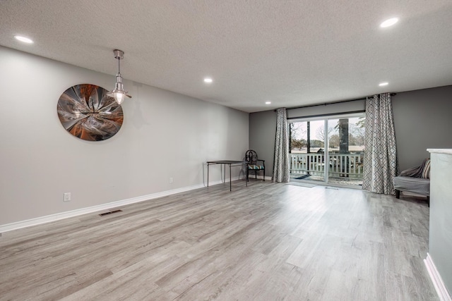 interior space featuring a textured ceiling and light wood-type flooring