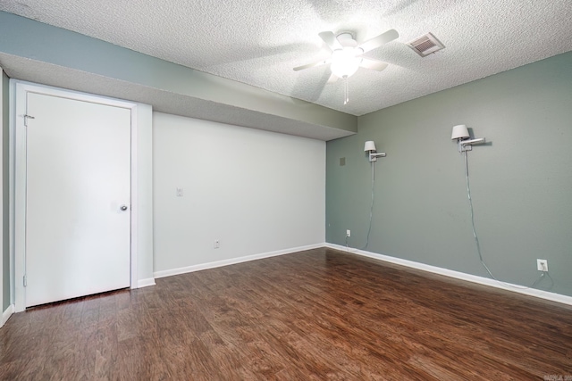 unfurnished room with a textured ceiling, ceiling fan, and dark wood-type flooring