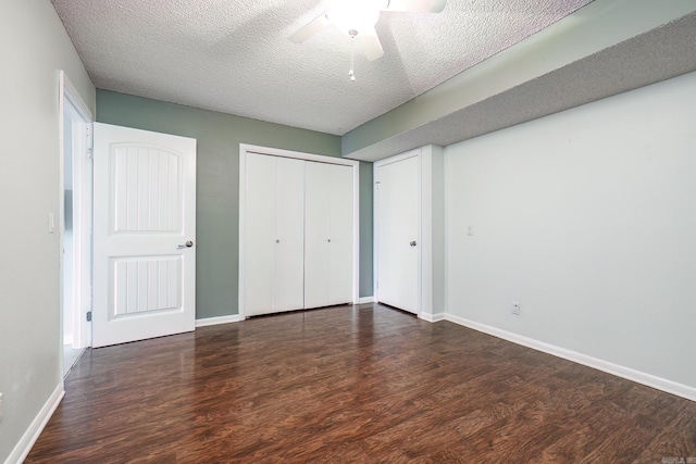 unfurnished bedroom featuring ceiling fan, dark hardwood / wood-style flooring, a textured ceiling, and a closet