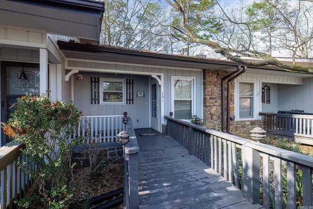 doorway to property with stone siding and covered porch