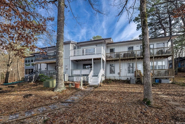 back of house with a balcony, central AC unit, and stairway