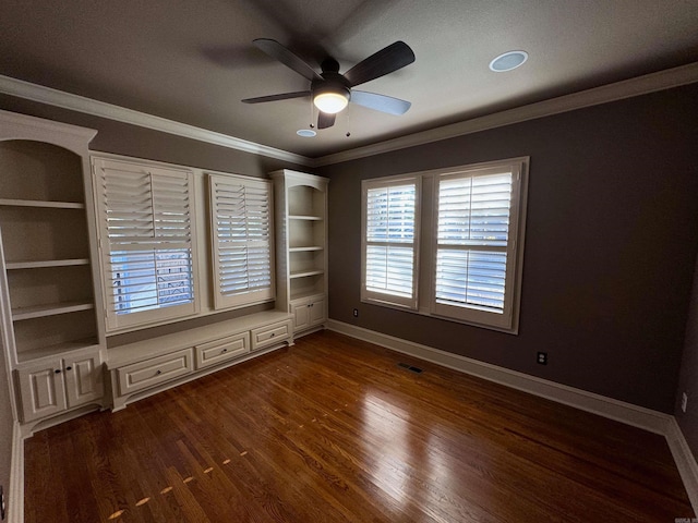 spare room with dark hardwood / wood-style flooring, built in shelves, a textured ceiling, ceiling fan, and crown molding