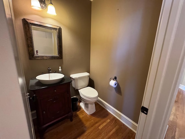 bathroom with vanity, hardwood / wood-style flooring, and toilet