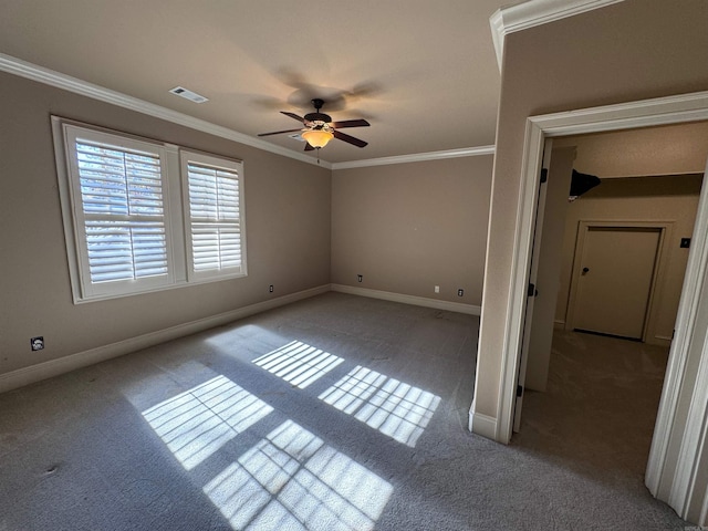 empty room with ceiling fan, crown molding, and light carpet