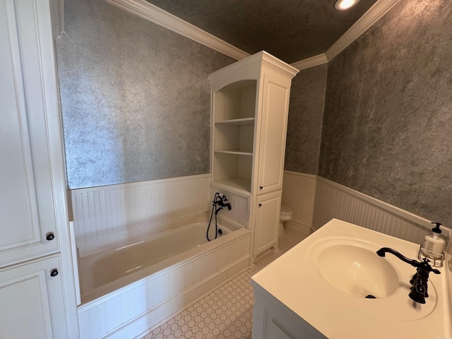 bathroom with crown molding, sink, a bath, and toilet