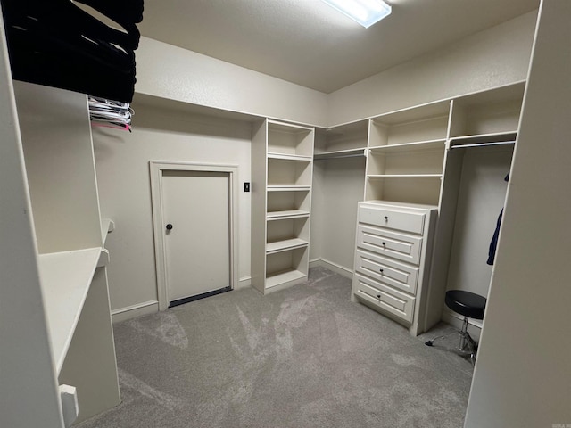 walk in closet featuring light carpet